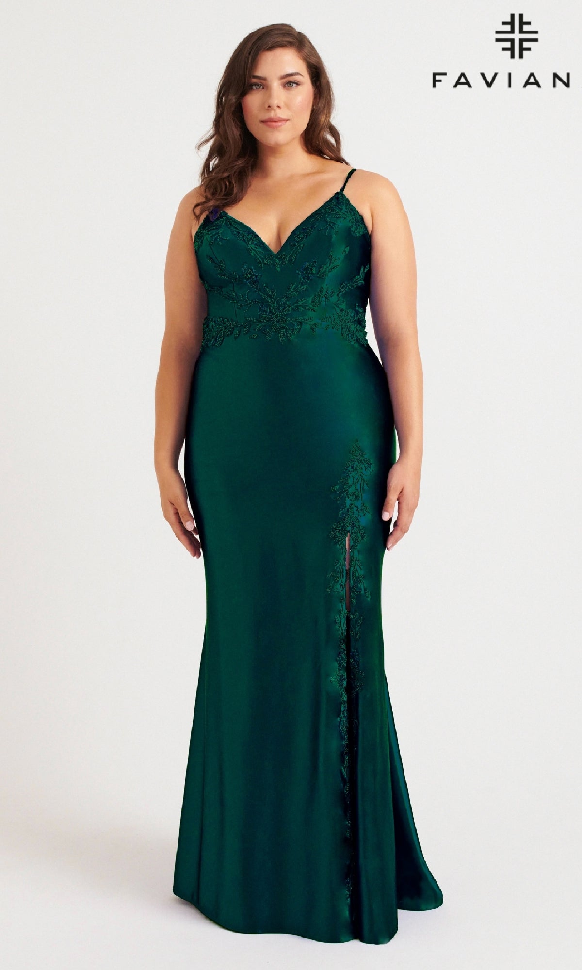 A woman models the Faviana 9562 Long Plus-Size Prom Dress in dark green satin with lace details, spaghetti straps, and a beaded bodice against a plain background. The Faviana logo appears in the top right corner.